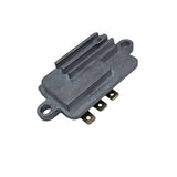 A silver metal electronic component with a ribbed heat sink and three gold-colored terminal pins, photographed on a light gray surface. 21066-7017 - REGULATOR-VOLTAGE - KAWASAKI ENGINE PARTS