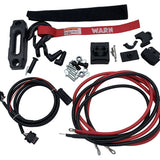 A battery cable and mounting kit laid out on a white background, including red and black cables, black plastic hardware, mounting brackets, a red warning strap, and small metal fasteners. 900-0743 - WINCH ASM, AXON 35-S - ARGO PARTS