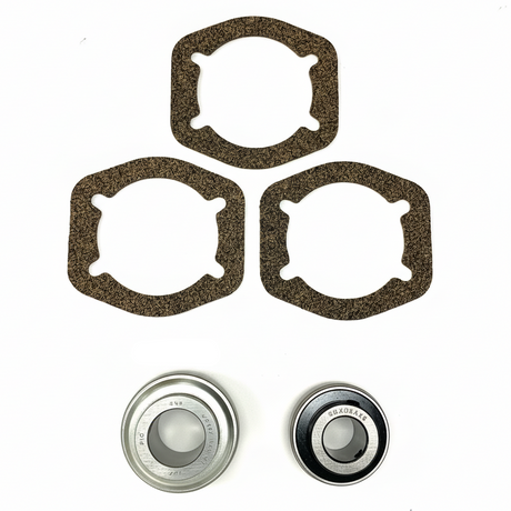 A set of mechanical parts on a white background, including three dark brown textured gaskets, two metal bearings. BK-201HDB-AM - HD 1.25" BEARING KIT - FRONT/REAR (2010-2017) - AFTERMARKET
